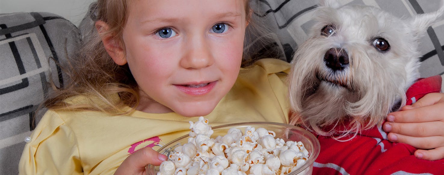baby and dog eating popcorn